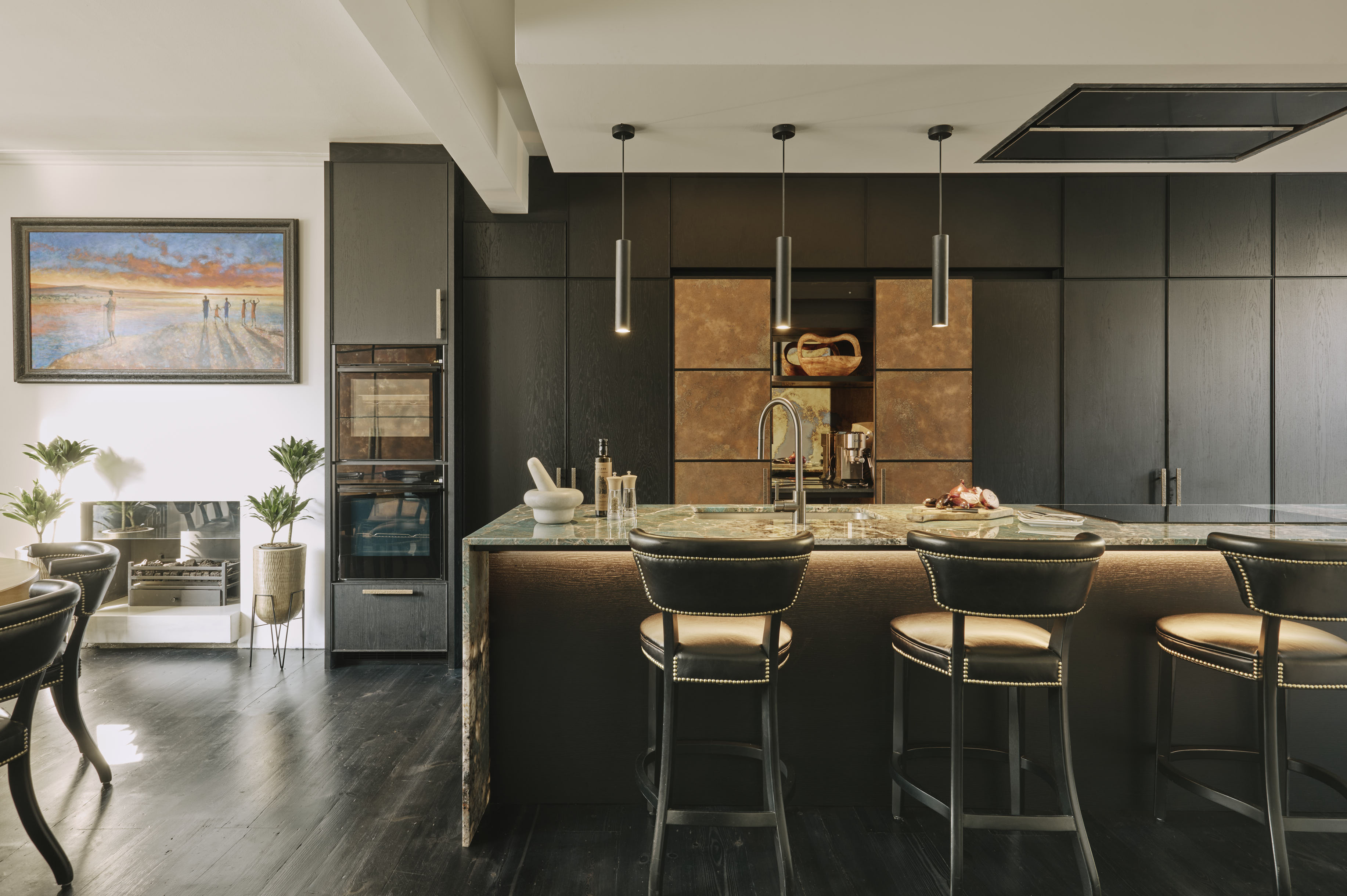 The Bermondsey kitchen features warm patinated copper against black-stained oak cabinetry.